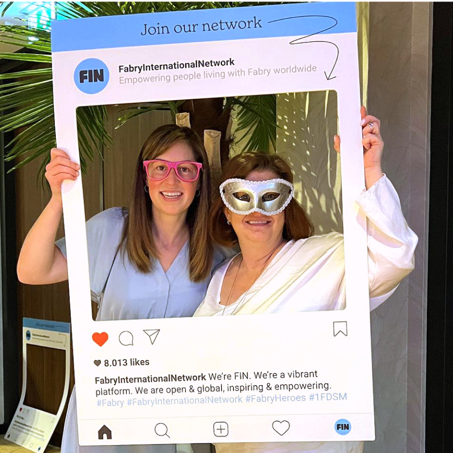 Two FIN employees pose inside an Instagram cutout